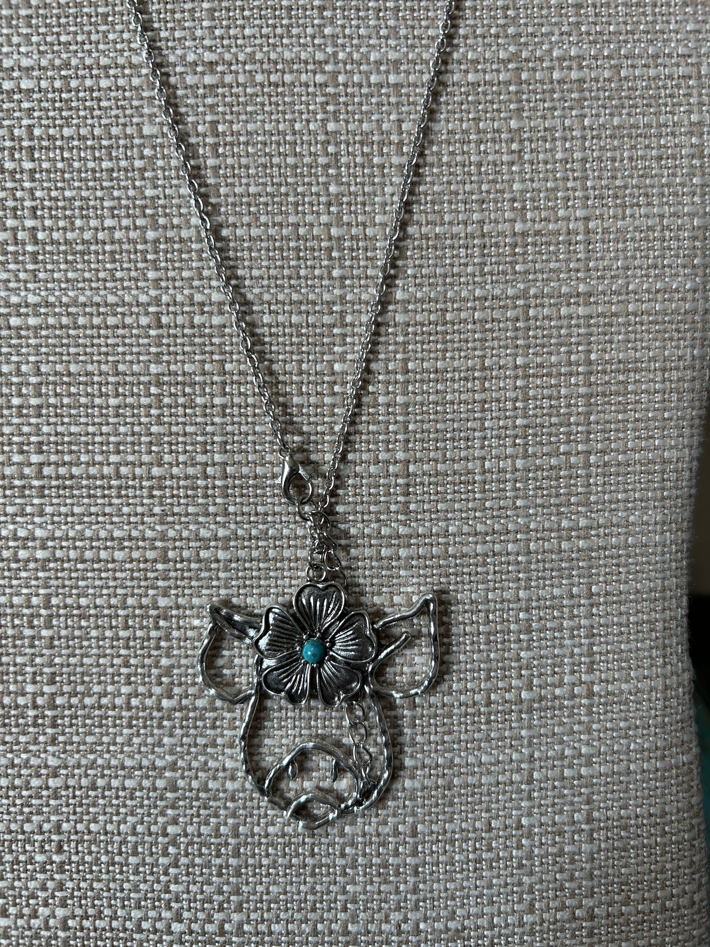 Silver Pig Necklace Featuring a Flower Design